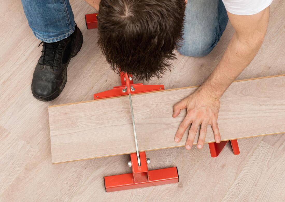 man cutting a wooden flooring